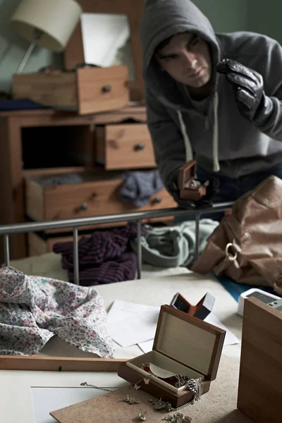 Вор крадет вещи из спальни во время взлома шланга — стоковое фото