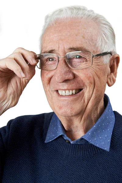 Пожилой человек примеряет новые очки — стоковое фото