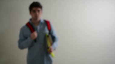 Erkek üniversite öğrencisi kamera ve gülümsüyor doğru yürüyor