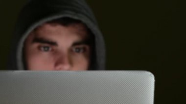 Cyber suç dizüstü ekran tarafından aydınlatılmış yüzü ile kullanma