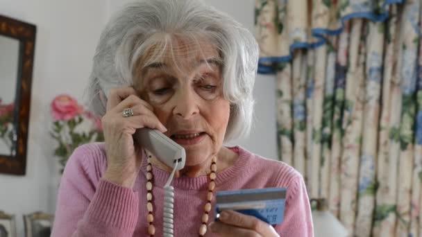 Senior Woman Giving Credit Card Details On The Phone — Stock Video