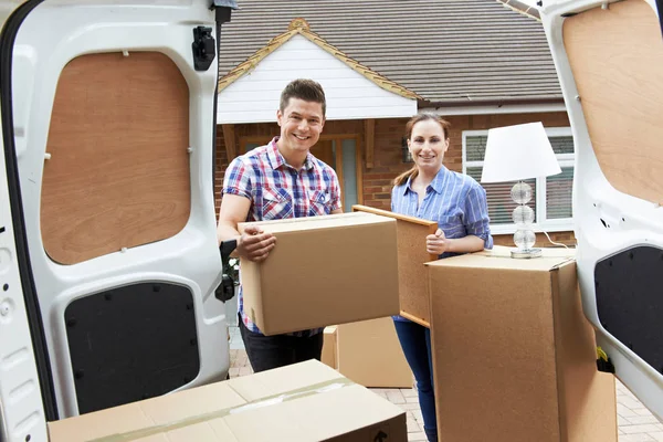 Casal jovem movendo-se para a nova casa descarregando Van de remoção — Fotografia de Stock