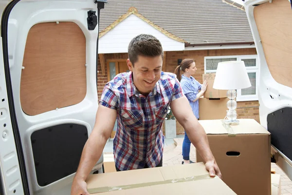 Casal jovem movendo-se para a nova casa descarregando Van de remoção — Fotografia de Stock