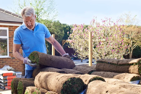 Liggande trädgårdsmästaren om torv för ny gräsmatta — Stockfoto