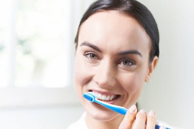 Kadın banyoda diş fırçası ile diş fırçalama