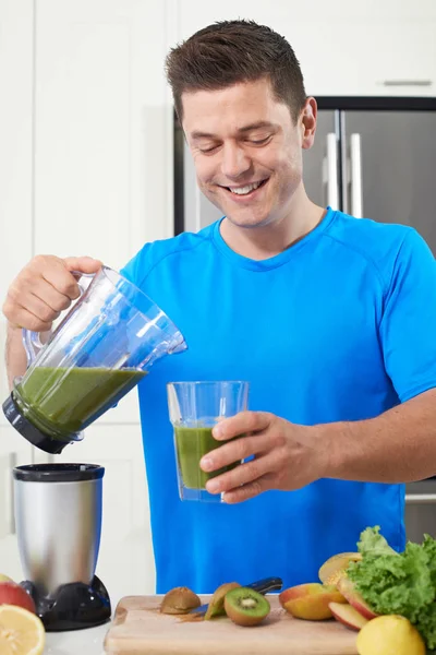 Male Athlete Making Juice Or Smoothie In Kitchen — Stock Photo, Image
