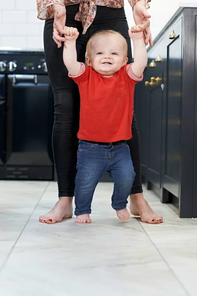 Mami, pomoc synka na procházku v kuchyni — Stock fotografie