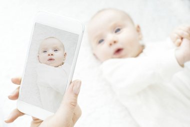 Anne kız bebek resim çekmek üstünde hareket eden telefon