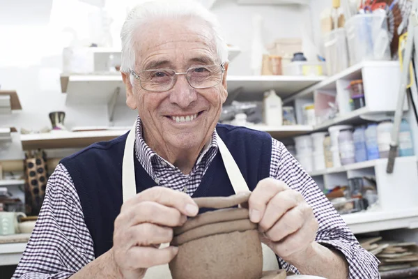 Uomo anziano che fa la pentola della bobina in studio di ceramica — Foto Stock