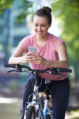 Döngüsü yolculuk ederken üzerinde cep telefonu kullanan genç kadın