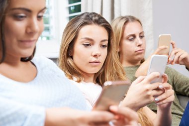 Genç kız evde cep telefonunu kullanarak grubu