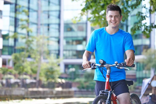 Portrait Of Young Man Cycling Next To River In Urban Setting — Stock Photo, Image