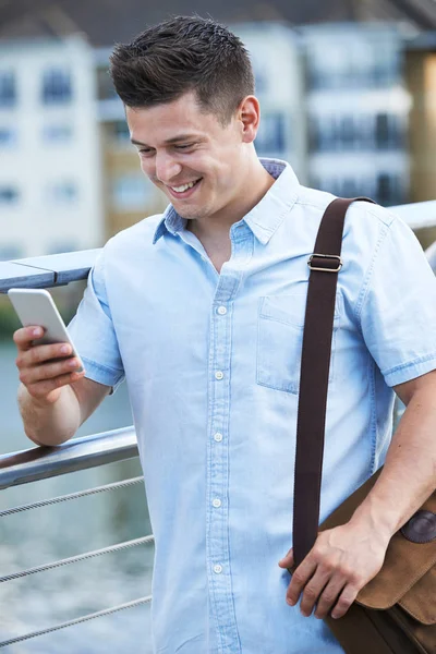 Hombre joven mensajes de texto en el teléfono móvil caminando al trabajo —  Fotos de Stock