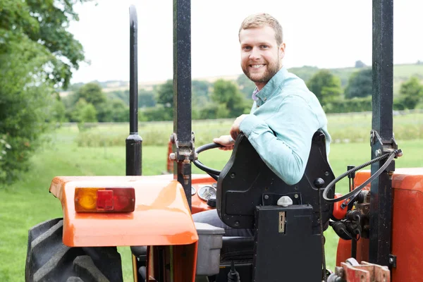 Ritratto di agricoltore seduto sul trattore in campo — Foto Stock