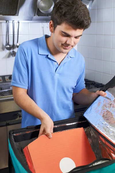Pizza Delivery Person Putting Food Into Insulated Bag In Restaur