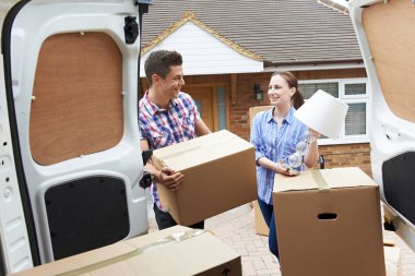 Young Couple Moving In To New Home  Unloading Removal Van clipart