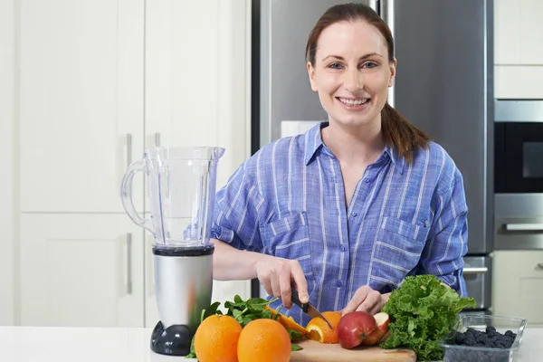 Porträtt av kvinna hugga frukt att sätta i Juicer — Stockfoto