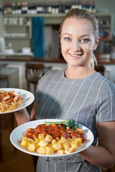 Cameriera che serve piatti di cibo nel ristorante — Foto Stock