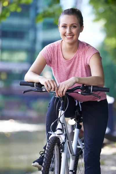 都会の川の横にある自転車の若い女性 — ストック写真