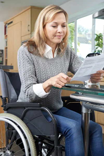 Gehandicapte vrouw In rolstoel lezing brief thuis — Stockfoto