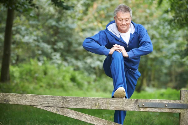Starší muž táhnoucí se na venkově běh — Stock fotografie