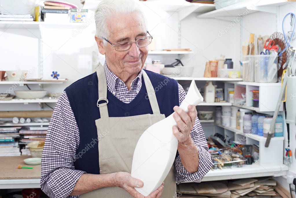 Senior Man Holding Vase In Pottery Studio