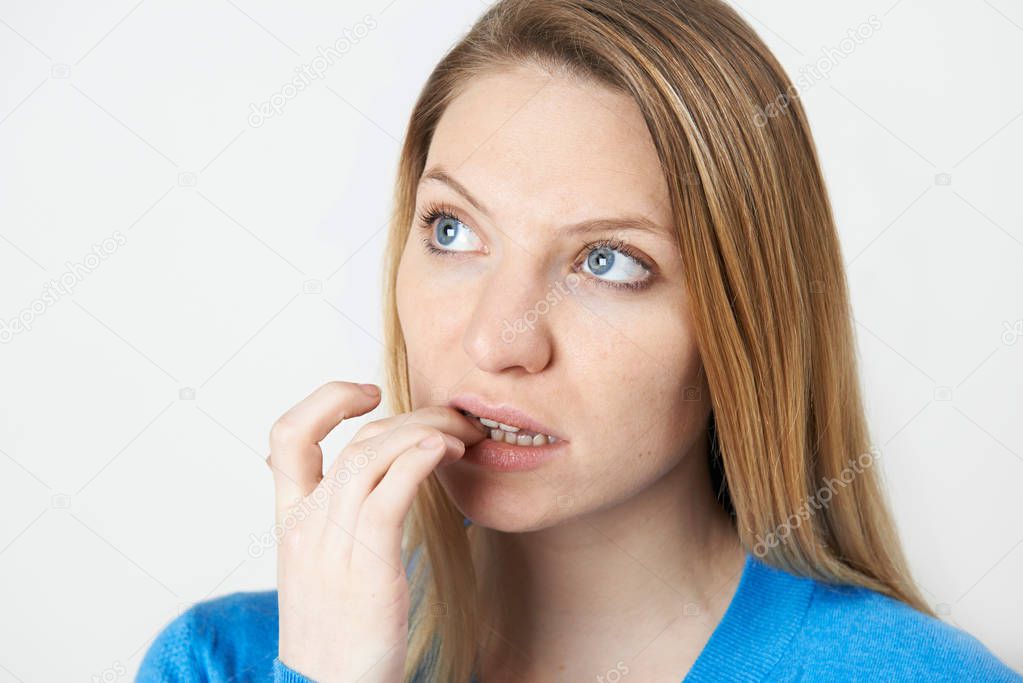 Studio Shot Of Nervous Woman Biting Nails