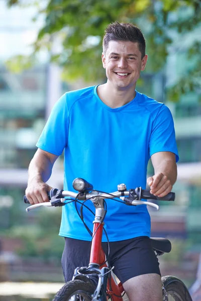 都会の川の横にある自転車の若い男の肖像 — ストック写真