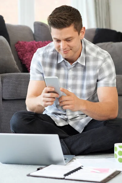 Manlig frilansande arbetstagare använder mobiltelefon hemma — Stockfoto