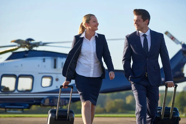 Businesswoman And Businessman In Discussion As They Walk Away From Helicopter — Stock Photo, Image