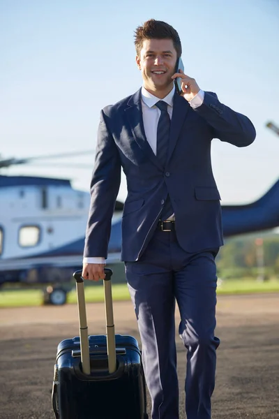 Бизнесмен уходит от вертолета, разговаривая на Mobil — стоковое фото