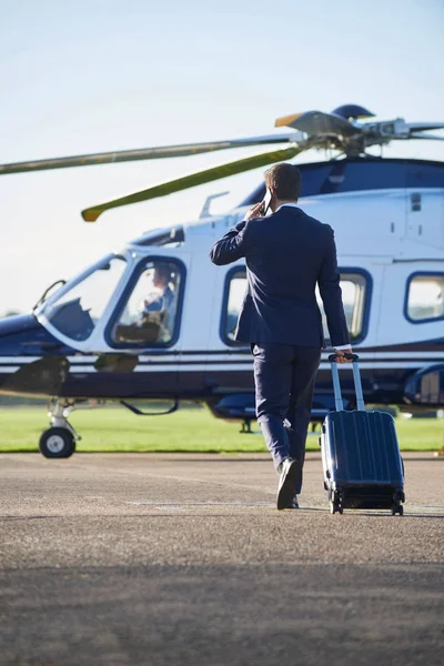 Businessman Walking Towards Helicopter Whilst Talking On Mobile — Stock Photo, Image