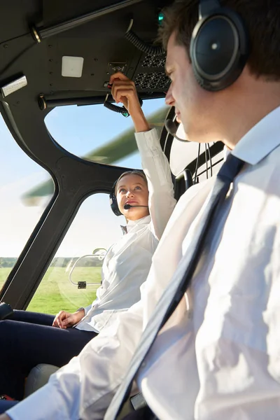 Pilot ve yardımcı pilot helikopter kokpitinde.