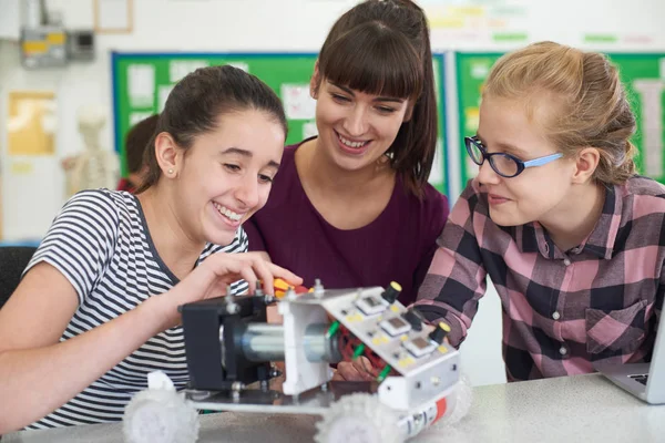 先生が科学ルでロボット工学を勉強して女子生徒に話しています。 — ストック写真