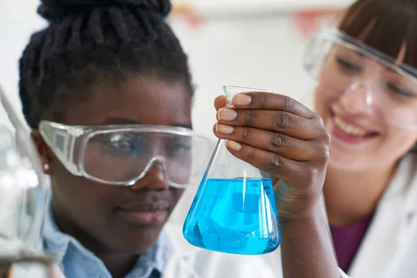 女子生徒と教師の化学実験を行なう — ストック写真