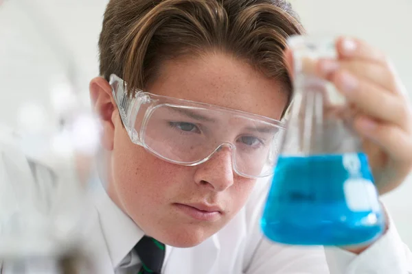 Чоловік учень проводить хімічний експеримент у класі науки — стокове фото