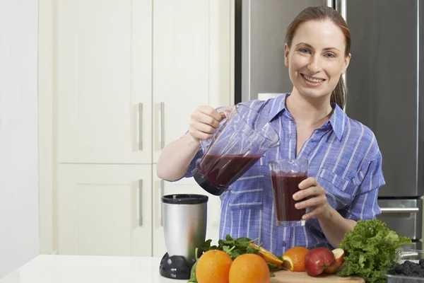 Portrét ženy dělat šťávu nebo Smoothie v kuchyni — Stock fotografie