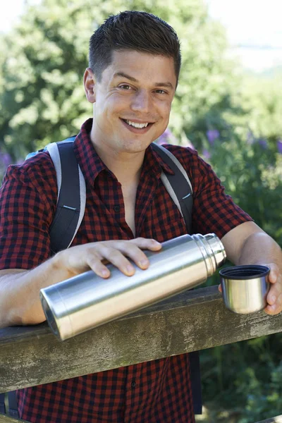 Man Pouring Hot Drink From Flask On Walk — Stock Photo, Image