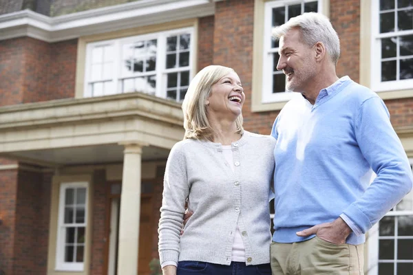 Lächelndes älteres Paar, das vor dem Haus steht — Stockfoto