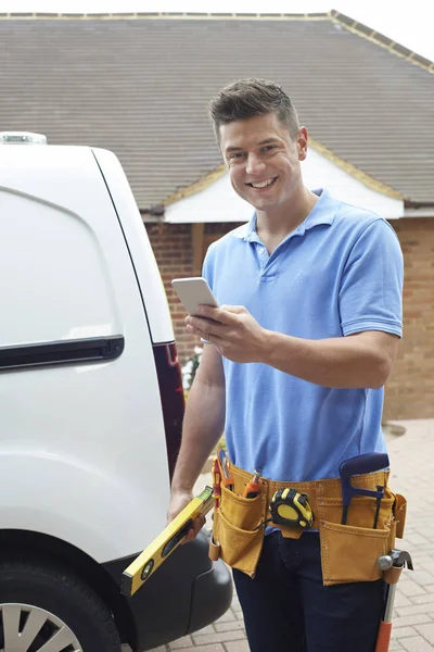 Builder med Van kontrollerar textmeddelanden på mobiltelefonen utanför Ho — Stockfoto