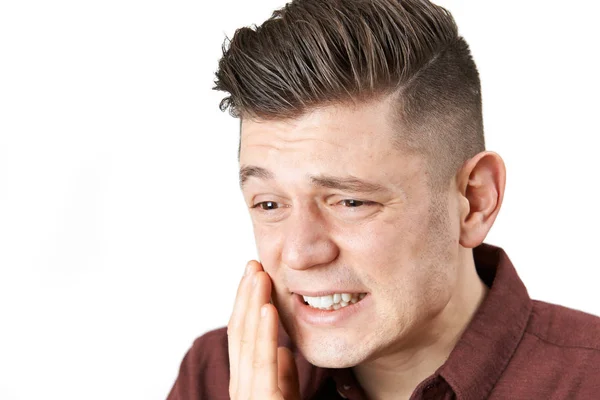 Estúdio tiro de jovem sofrendo com dor de dente — Fotografia de Stock