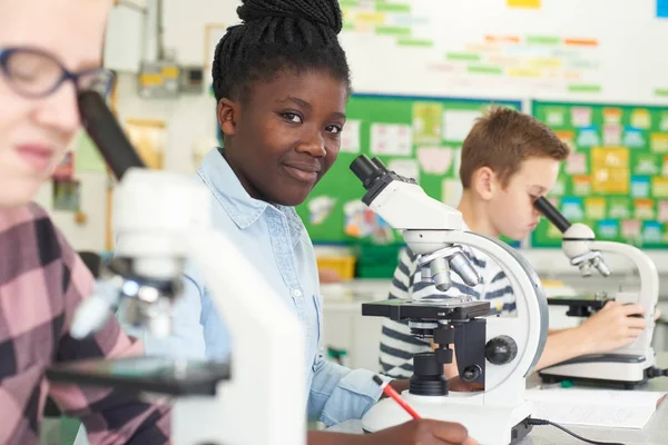 Gruppo di alunni che utilizzano microscopi in classe di scienze — Foto Stock