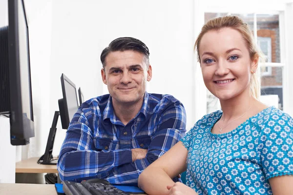 Oudere Man opleiding jonge vrouw op de Computer In kantoor — Stockfoto