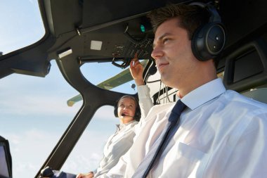 Pilot ve yardımcı pilot helikopter kokpitinde.