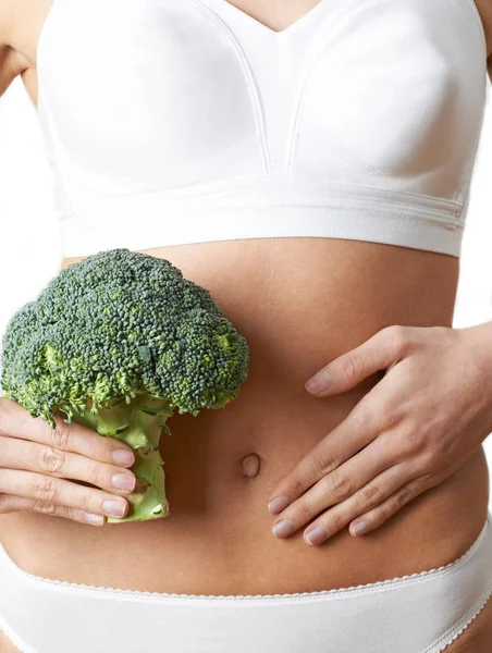 Close Up Of Woman In Underwear Holding Bunch Of Broccoli And Tou — Stock Photo, Image