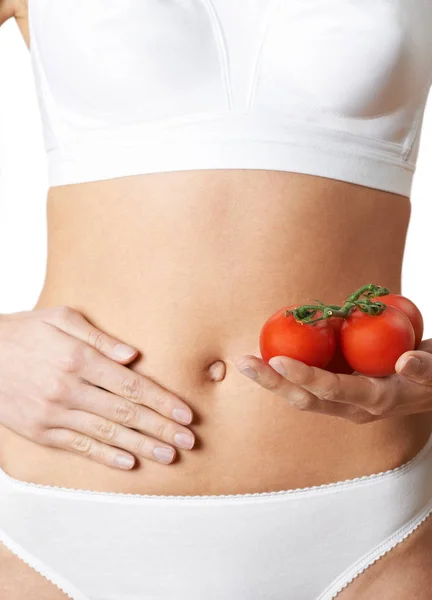Närbild av kvinna i underkläder håller tomater och röra Sto — Stockfoto