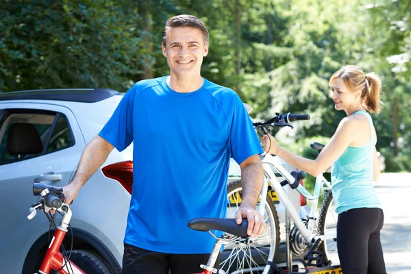 Pareja madura tomando bicicletas de montaña de bastidor en el coche — Foto de Stock