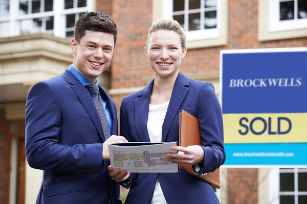 Portrait Of Male And Female Realtors Standing Outside Residentia — Stock Photo, Image