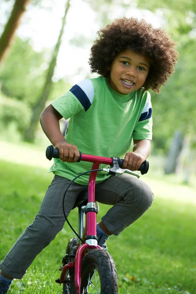 Jeune garçon apprenant à faire du vélo dans le parc — Photo