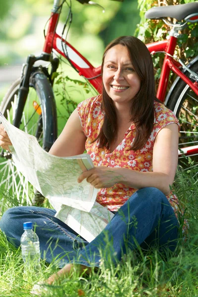 Portret van een volwassen vrouw op fietstocht In platteland lezing Ma — Stockfoto